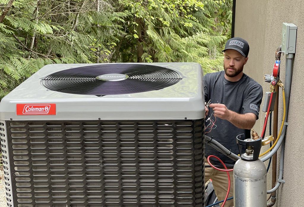 A technician servicing a residential outdoor air conditioning condenser