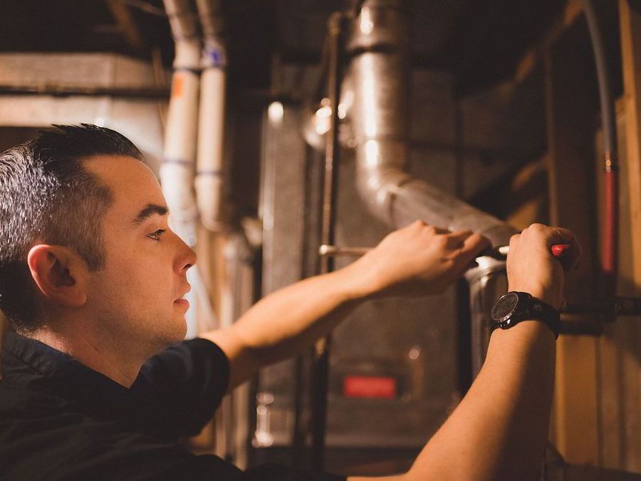 A technician working inside a residential heating system